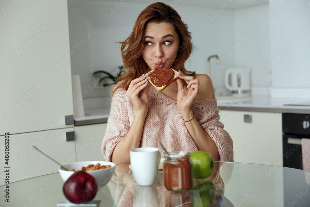Caucasian girl having breakfast at home kitchen