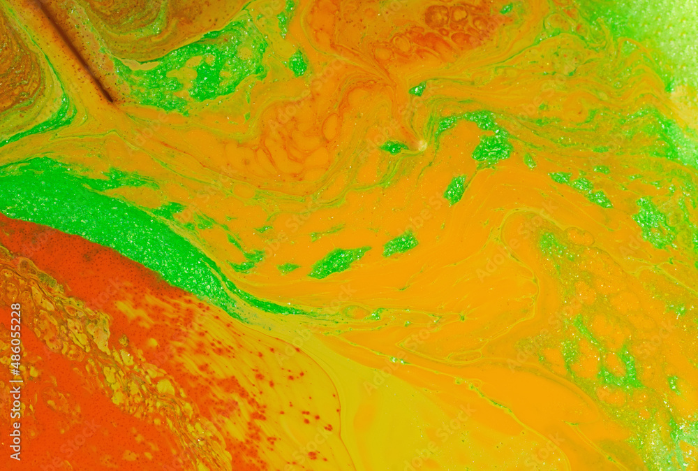 Beautiful liquid texture of the nail polish.Orange,green,yellow colors.Background with copy space.Fluid art,pour painting technique.Good as digital decor.