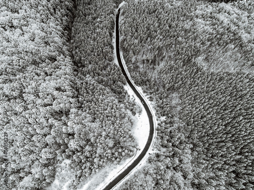 Aerial view above Carpathian mountains. Frosty forest in mountains. Road on the mountains. Snow covered tree, snow on the ground © Богдан Магдич