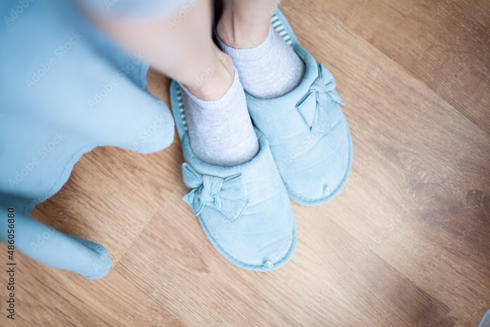 Women's legs in slippers of home turquoise Women's legs in slippers of home turquoise