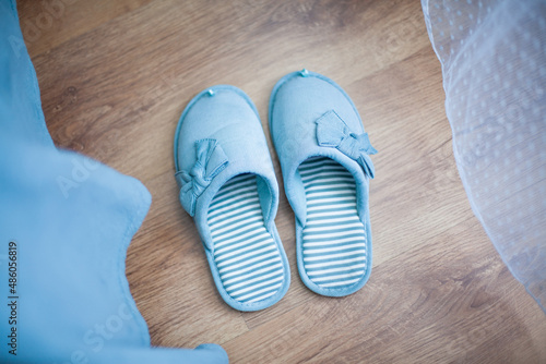 Slippers of female home turquoise color stand on the floor (top view)