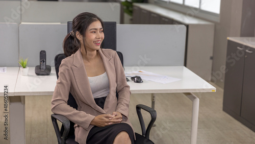 Young female business trainee or intern in smart attire is ready to start her assignment with computer notebook in an office. Female business worker with happy smile prepare to start her day