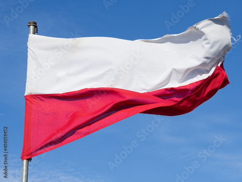 Biało czerwona flaga Polski na błękitnym niebie