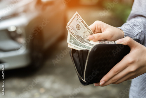 Businessman Person holding a wallet in the hands of take money out of pocket stand front car prepare pay by installments - insurance, loan and buying car finance concept insurance, payment a car