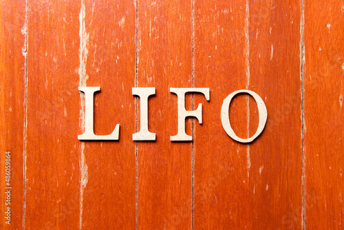 Alphabet letter in word LIFO (abbreviation of last in first out) on old red color wood plate background photo