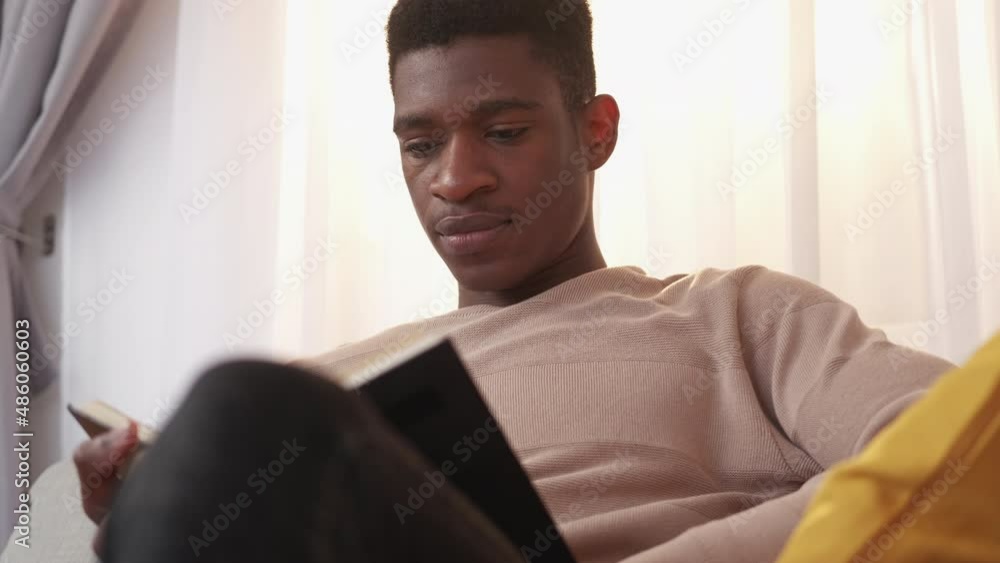 Reading man. Book knowledge. Literature intelligence. Mindful young guy bookworm enjoying interesting bestseller story at home on couch. Reading man. Book knowledge. Literature intelligence. Mindful young guy bookworm enjoying interesting bestseller story at home on couch.
