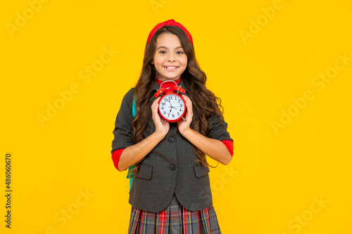 kid in uniform on yellow background. september 1. happy childhood. child with alarm clock. © be free