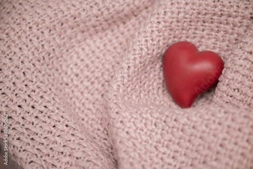 Red heart on a knitted pink textile texture. Valentine s day background