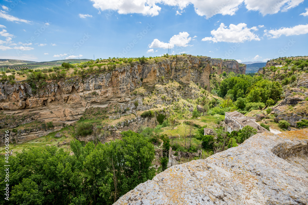 City canyon perspective. Alhama de Granada, Andalusia, Spain. Beautiful and interesting travel destination in the warm Southern region. Public street view.