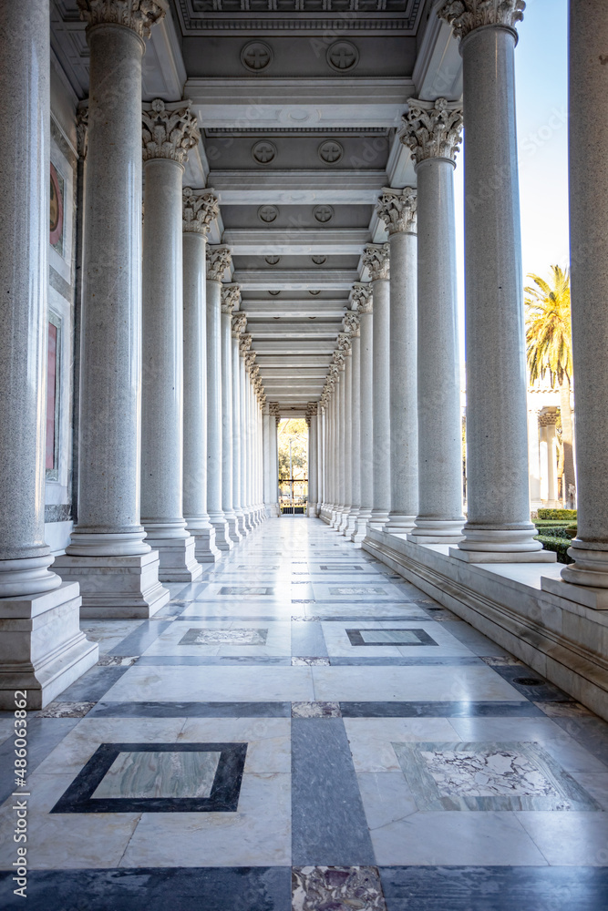 a long corridor is surrounded by a wall of tall marble columns