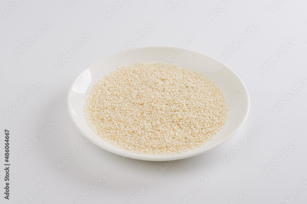 white sesame seeds on a white plate on a white background white sesame seeds on a white plate on a white background