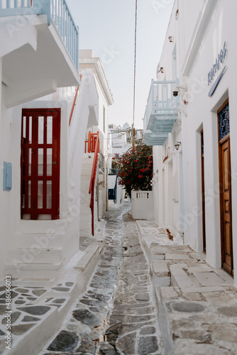 Picturesque narrow blue and white cobble street and traditional Greek houses in Mykonos Island, Greece