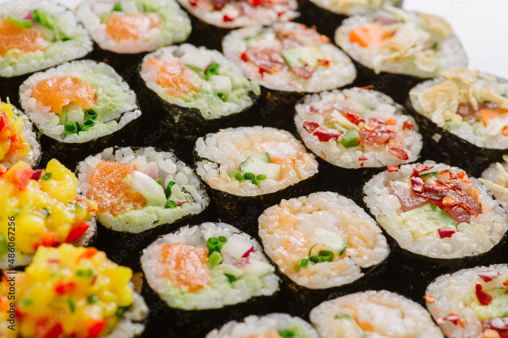 Maki Sushi Rolls set on wooden board. Japanese traditional Cuisine. White background. Maki Sushi Rolls set on wooden board. Japanese traditional Cuisine. White background.