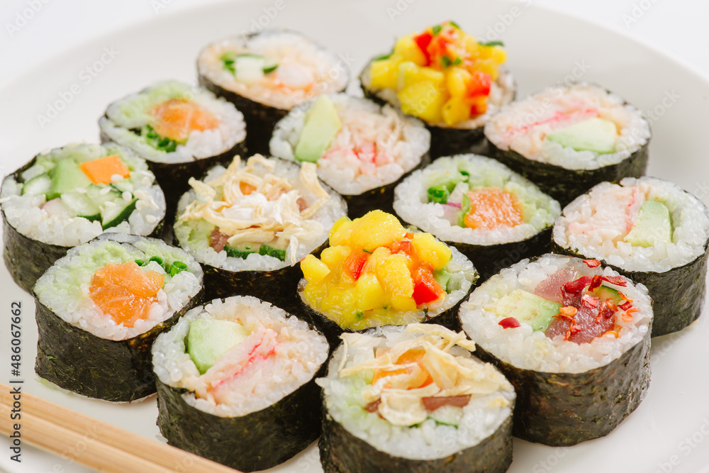 Maki Sushi Rolls set on wooden board. Japanese traditional Cuisine. White background. Maki Sushi Rolls set on wooden board. Japanese traditional Cuisine. White background.