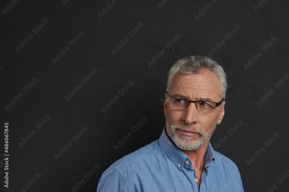 Obraz premium Concentrated senior man in glasses looking away