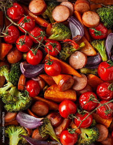 oven baked vegetables and sausages  healthy lunch  sweet potato onion tomato broccoli