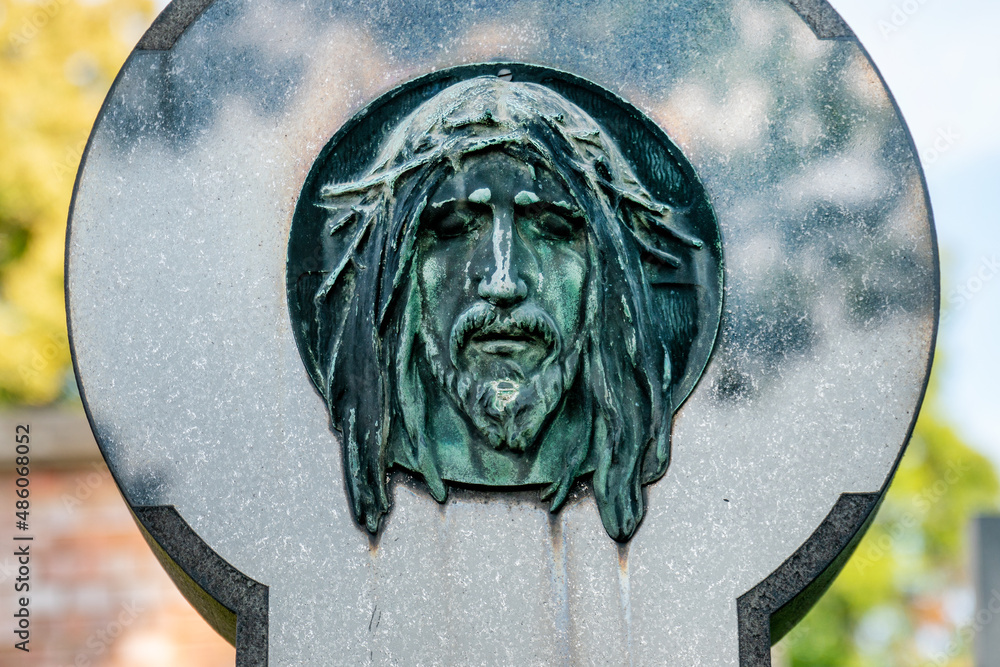 The face of a bearded man similar to jesus is carved from stone. Sculpture.