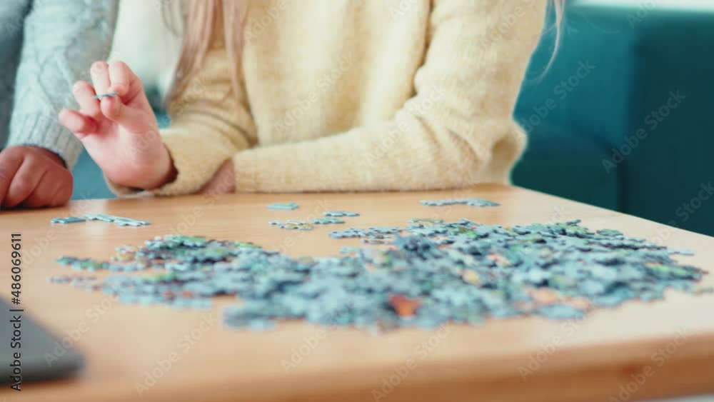 Hands of multinational girls collects puzzles at home Hands of multinational girls collects puzzles at home