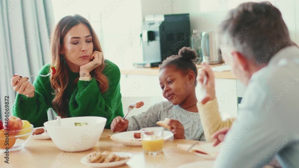 Cheerful multinational family eating breakfast at home Cheerful multinational family eating breakfast at home