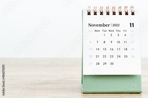 November 2022 desk calendar on wooden background.