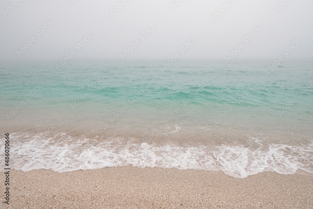 Blue azure sea and wave in white fog (haze)  as background