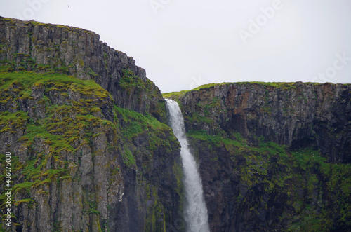 Breathtaking beautiful nature landscape scenic scenery view of Grundarfjordur in Iceland with green gras, mountains, volcanoes, sheep and waterfall cascade beach birds photo