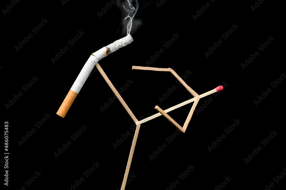 Quit Smoking Concept - match man kicks off a cigarette over black background
Quit Smoking Concept - match man kicks off a cigarette over black background