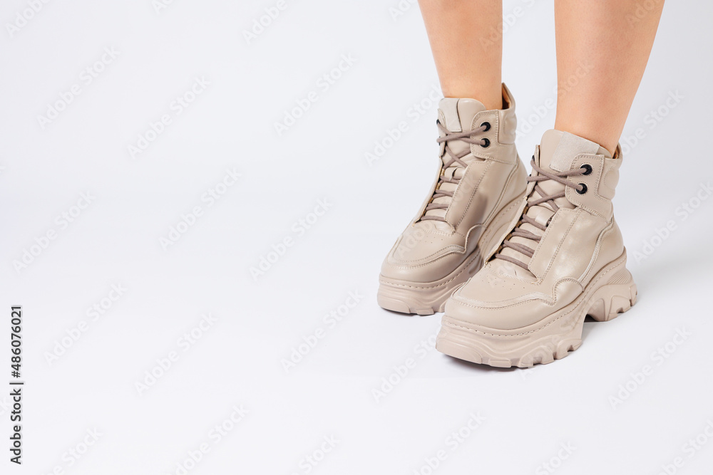 Female legs in beige leather shoes from the new collection on a white background female legs in fashionable shoes made of eco-leather spring 2022.