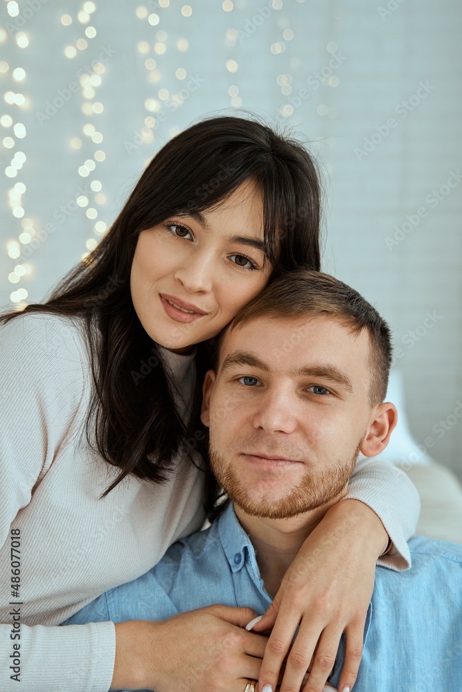 Happy girl hugging a guy in a blue shirt. Attractive couple posing together for a family photo. Happy girl hugging a guy in a blue shirt. Attractive couple posing together for a family photo.
