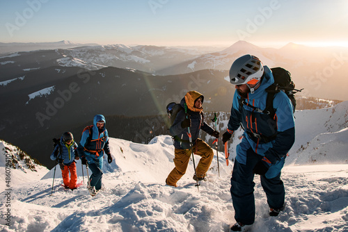 Wallpaper Mural group of male tourists climbing up at snow-covered mountain trail against the backdrop of a beautiful winter mountain landscape Torontodigital.ca