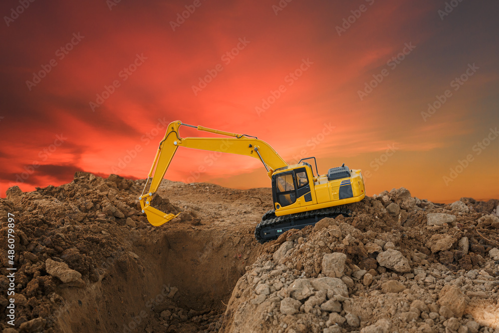 Excavator with Bucket are digging analyze the soil in the construction site on the orange Sky background Excavator with Bucket are digging analyze the soil in the construction site on the orange Sky background