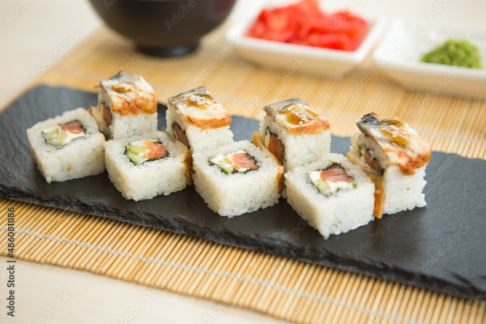Maki roll with salmon, popular Japanese cuisine. Sushi roll with fish, cream cheese and vegetables Maki roll with salmon, popular Japanese cuisine. Sushi roll with fish, cream cheese and vegetables