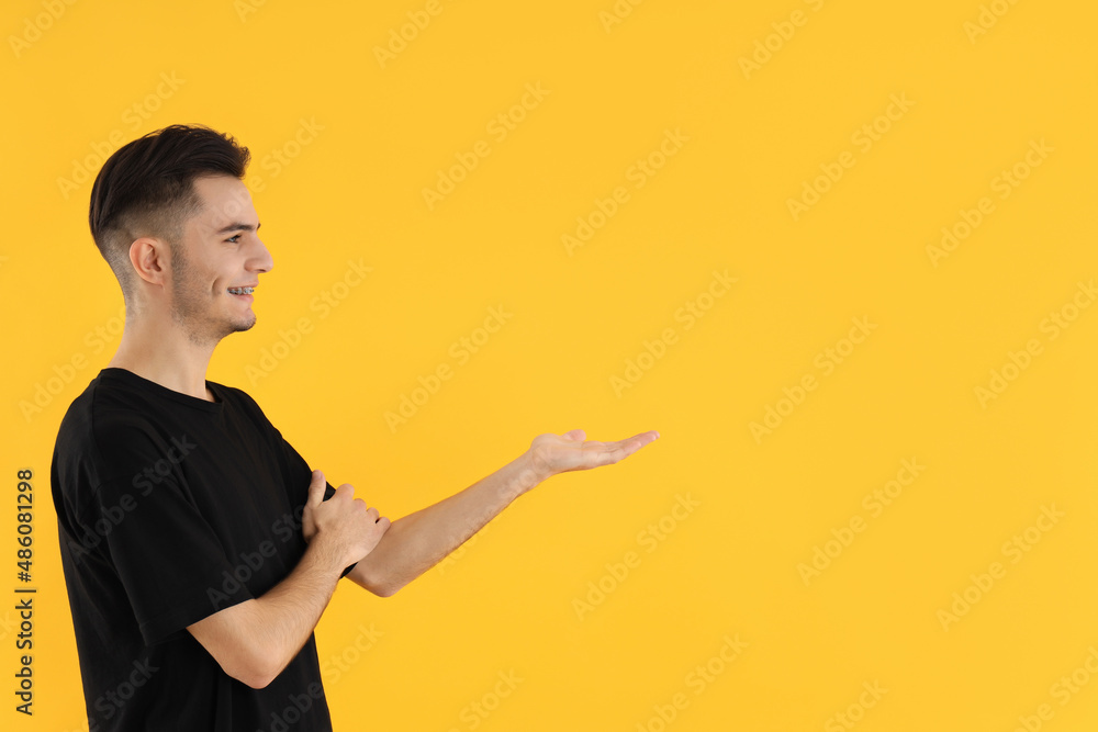 Attractive young man in t-shirt on yellow background Attractive young man in t-shirt on yellow background