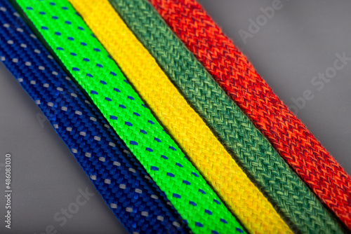 colored laces standing on a silver background. colorful accessories used in textile production.