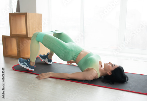 Fitness, home and diet concept - woman doing exercise on floor at home.