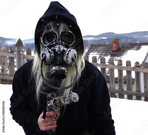 Obraz na plátně Armed steampunk person sitting spying and keeping low profile with gas mask helm
