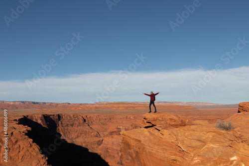 Young man opening arms at horseshoe bend in the grand canyon