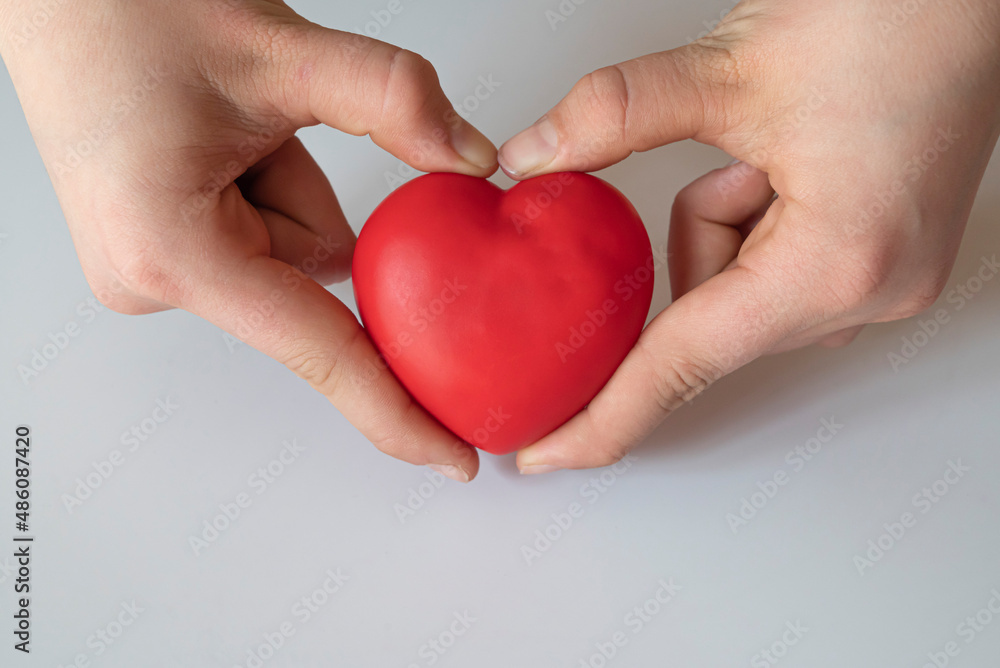 Obraz premium boy holding red heart. Organ donation and insurance concept. World heart health concept. World organ donation day. Concept of healthy heart for healthy life.