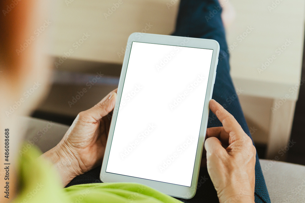 Close up of adult man hands typing on tablet - Man holding pc tablet at home with blank mock up white empty screen - mockup copyspace display for shopping online, job search, advertising
