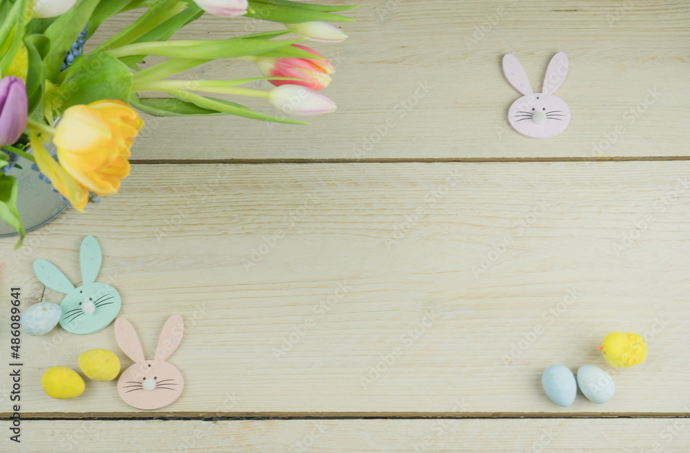 Wielkanoc, tło na życzenia z tulipanami, króliczkami i jajkami, aranżacja na drewnianym stole. - obrazy, fototapety, plakaty 