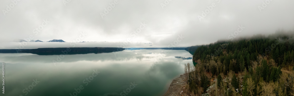 Obraz premium Aerial Panoramic View of Canadian Mountain Landscape covered in fog over Harrison Lake. Winter Season. British Columbia, Canada. Nature Background Panorama