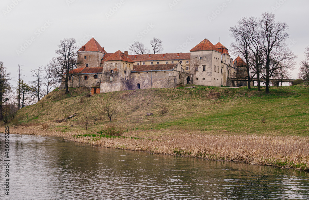 Ancient Svirzh castle by the lake in early spring. Lviv region, Ukraine