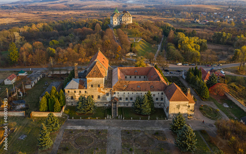 Aerial view of Capuchin monastery 1737 year Roman Catholic Church St.Anthony at sunset, in background of castle in the village of Olesko, Ukraine