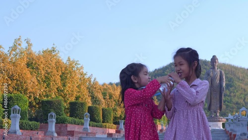 Slow motion scene of  6-year-old Asian girl shares water with friends to eat, dispensation, share 