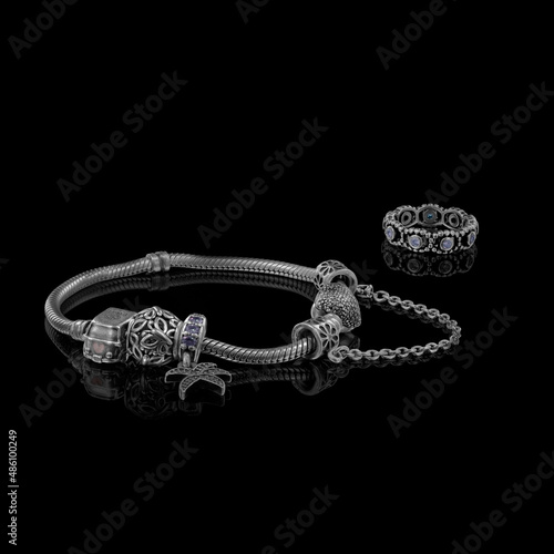 Fotografi A beautiful, expensive pandora bracelet lies on a table on a black background