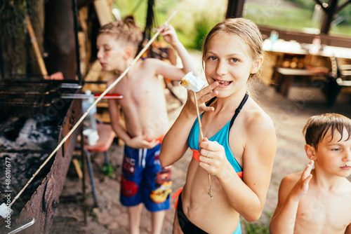 Fotografi Children eating marshmallows. Outdoor leisure childhood concept.
