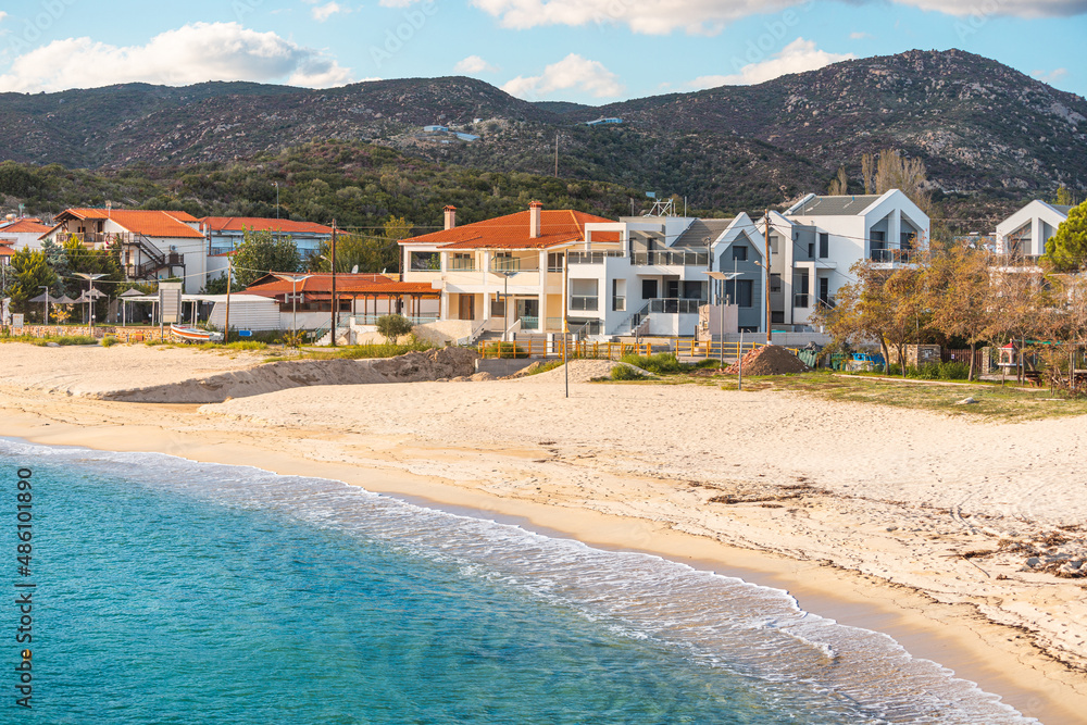 Obraz premium Houses and villas in a resort town Kalamitsi in Sithonia, Halkidiki, Greece on mountain slope at the Mediterranean Sea. Real estate and urban development concept