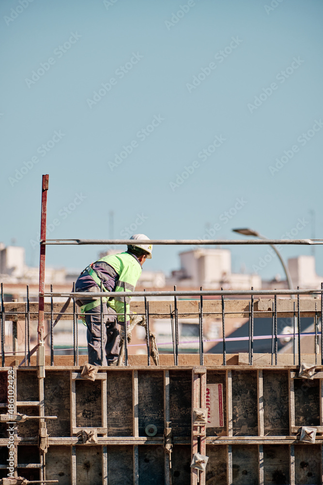 Construction worker working at heights holding a concrete hose Construction worker working at heights holding a concrete hose