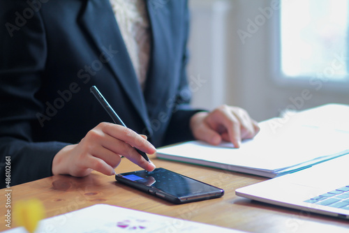 The businesswoman is reviewing the results from the documents prepared to report the earnings at a meeting to the investors about the annual profit. Young businesswoman checking annual results