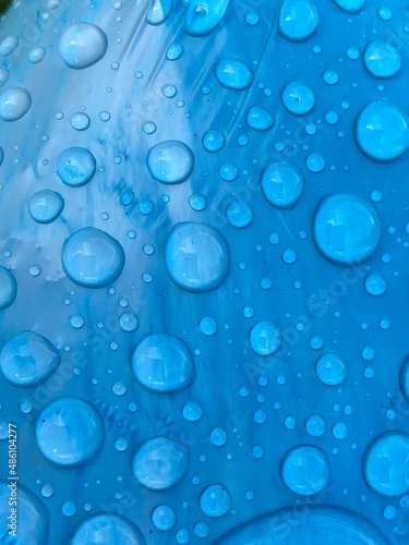 rain water drops droplet bubble on blue cyan turquoise plastic background with copy space 